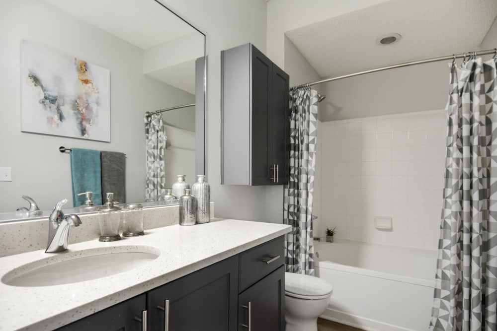 Quartz countertop and a large vanity mirror in a model home's bathroom at Ellington Midtown in Atlanta, Georgia