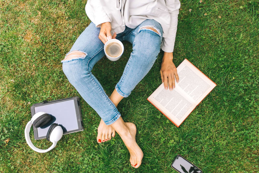 Woman reading a book in the park in Austin, Texas near Residences at The Triangle