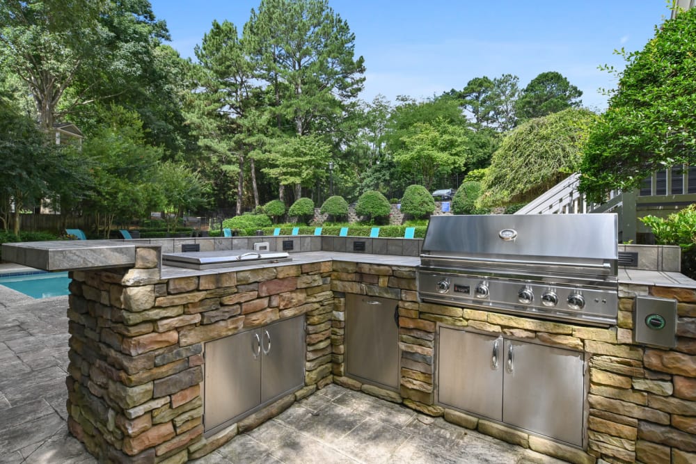 Gas grills at the barbecue area with a view of the pool at Crest at Riverside in Roswell, Georgia