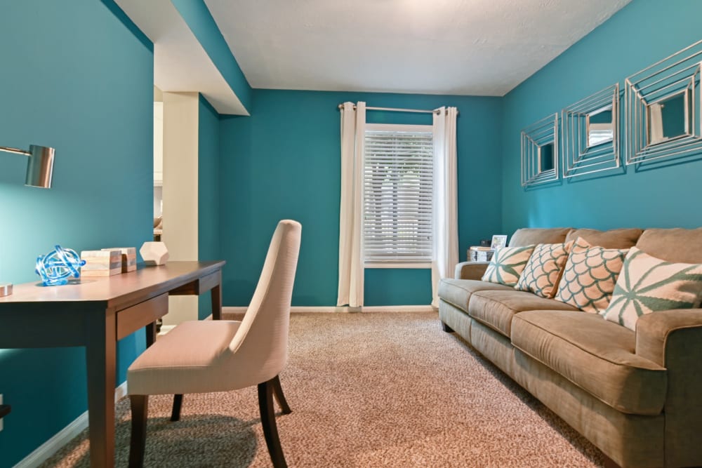 Den with accent walls and modern furnishings in a model apartment at Crest at Riverside in Roswell, Georgia