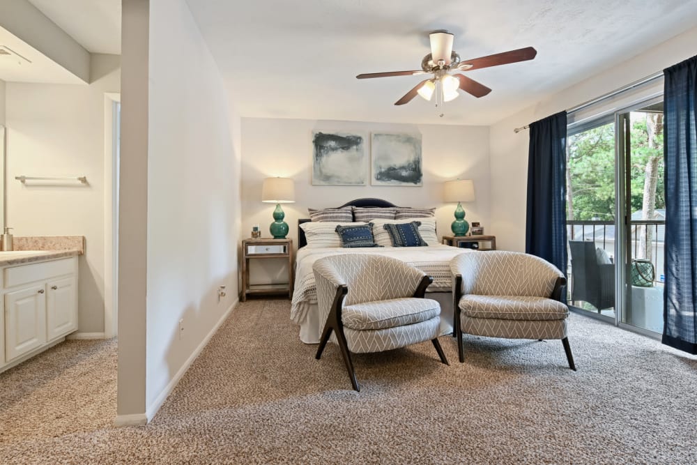 Ceiling fan and plush carpeting in a model apartment's primary bedroom at Crest at Riverside in Roswell, Georgia