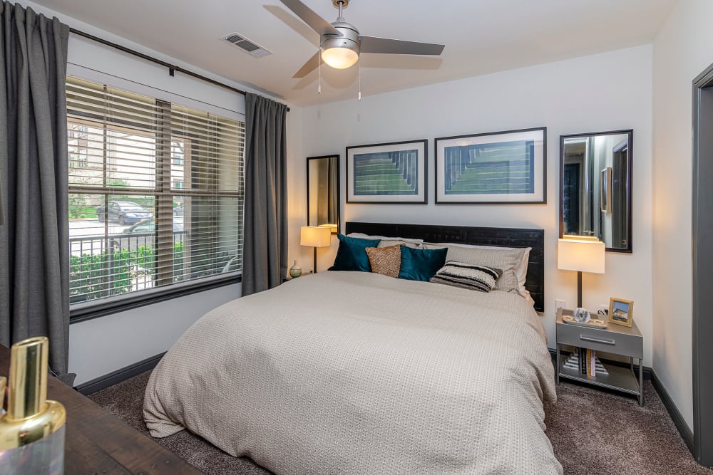 Ceiling fan and plush carpeting in the primary bedroom of a model home at Twin Creeks Crossing in Allen, Texas