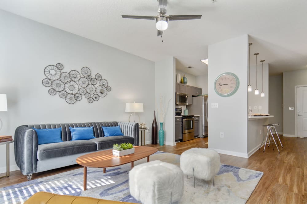 Well-furnished living area with a ceiling fan and hardwood flooring in a model apartment at Ellington Midtown in Atlanta, Georgia