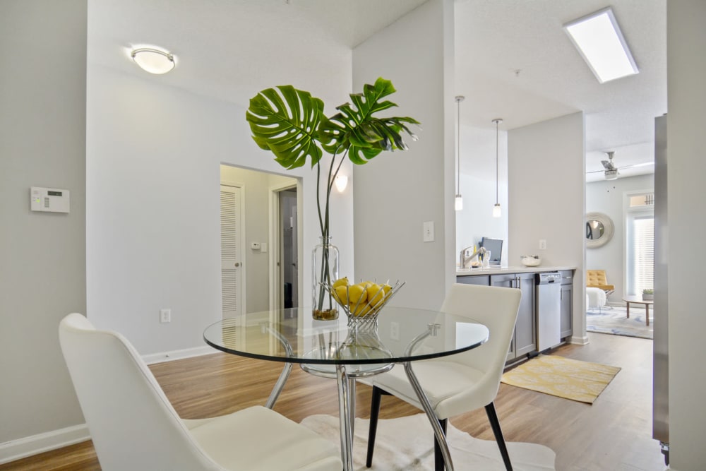 Dining area with a view of the kitchen and living space in an open-concept model apartment at Ellington Midtown in Atlanta, Georgia
