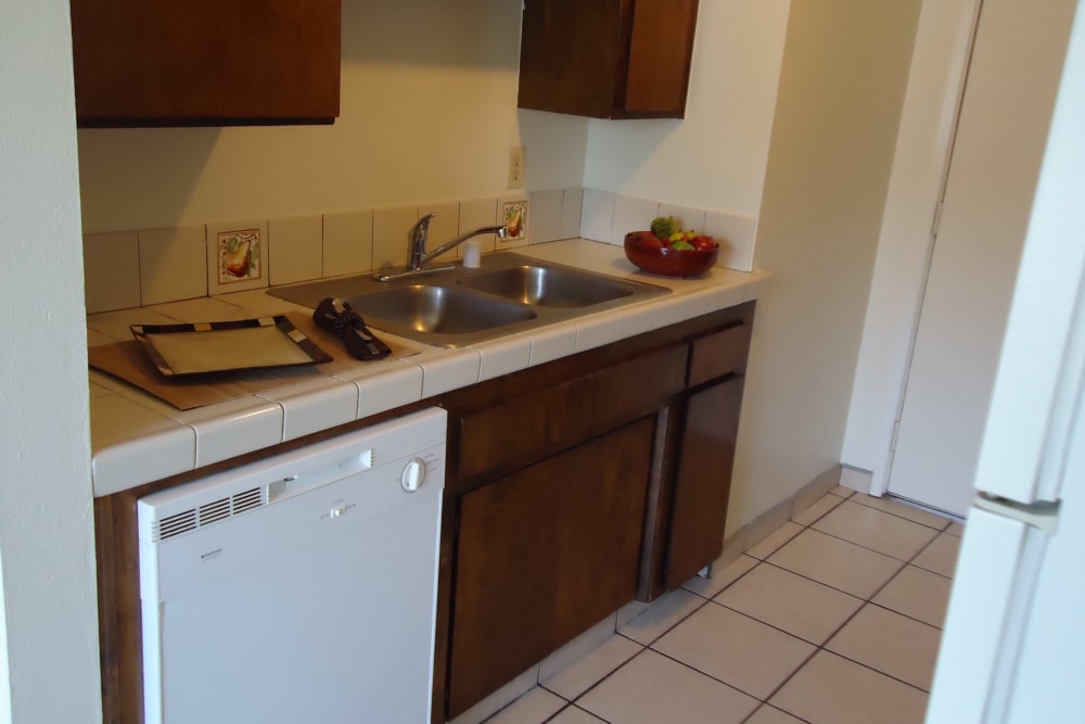 Kitchen unit with tile floor at Olympus Court Apartments in Bakersfield, California