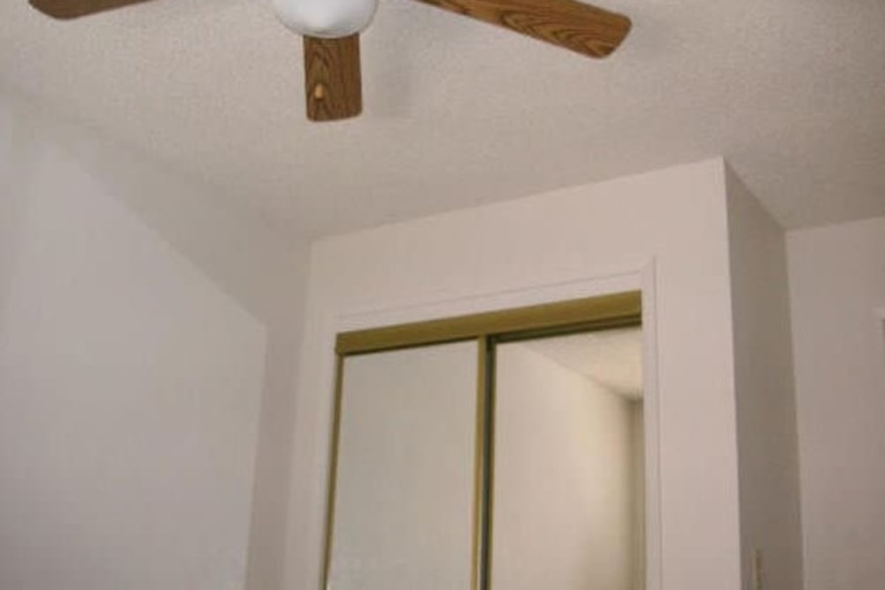 Bedroom with closet and ceiling fan at Olympus Court Apartments in Bakersfield, California