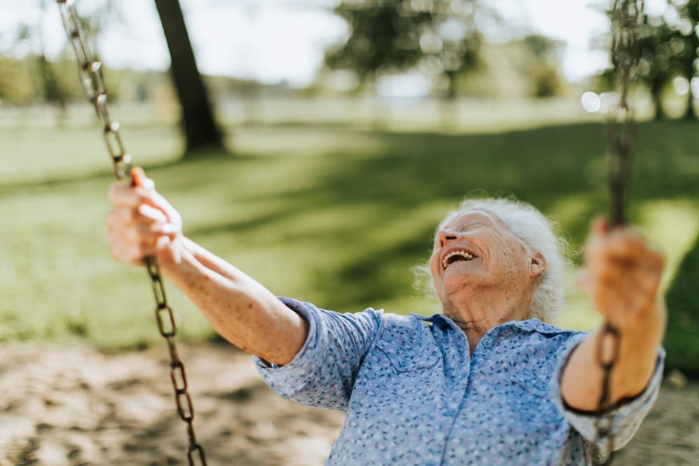 Resident smiling while swinging on swing at Emery Place in Robins, Iowa