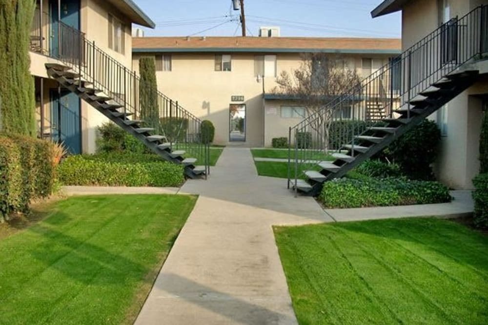 View of the exterior landscape and stairwells at Highland View Court in Bakersfield, California