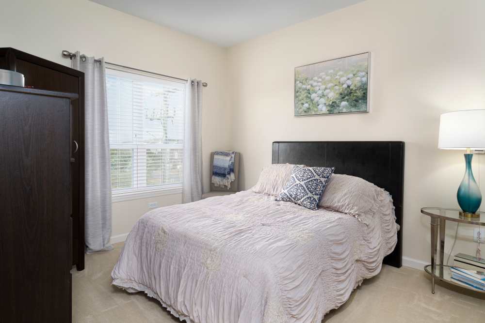 Bright bedroom with large bed and a window with curtains at Harmony at Spring Hill in Lorton,Virginia