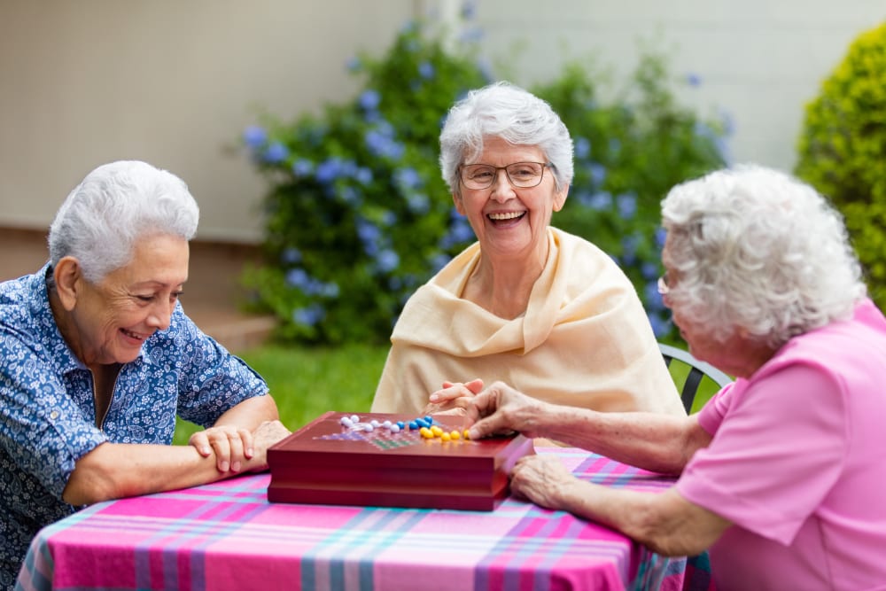 Resident friends playing a game outside at Merrill Gardens. 