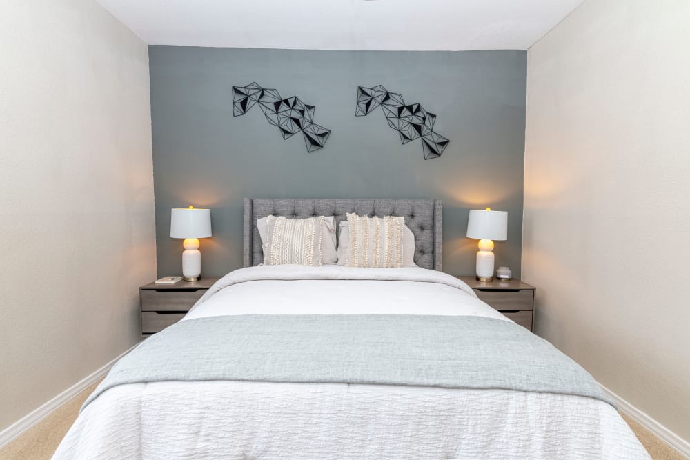 Well decorated model bedroom with two bedside lamps at The Lyndon in Irving, Texas