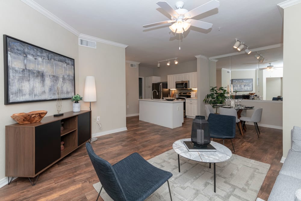 Well decorated model living room with blue accent chairs at The Lyndon in Irving, Texas