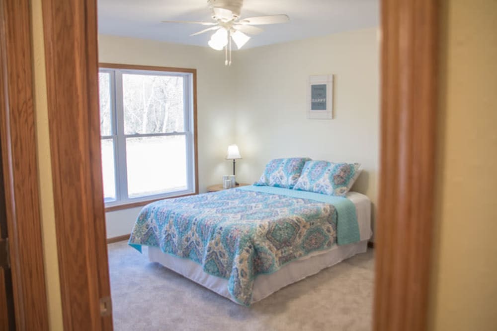 Bedroom with a large window in a townhome at Arlington Place Oelwein in Oelwein, Iowa
