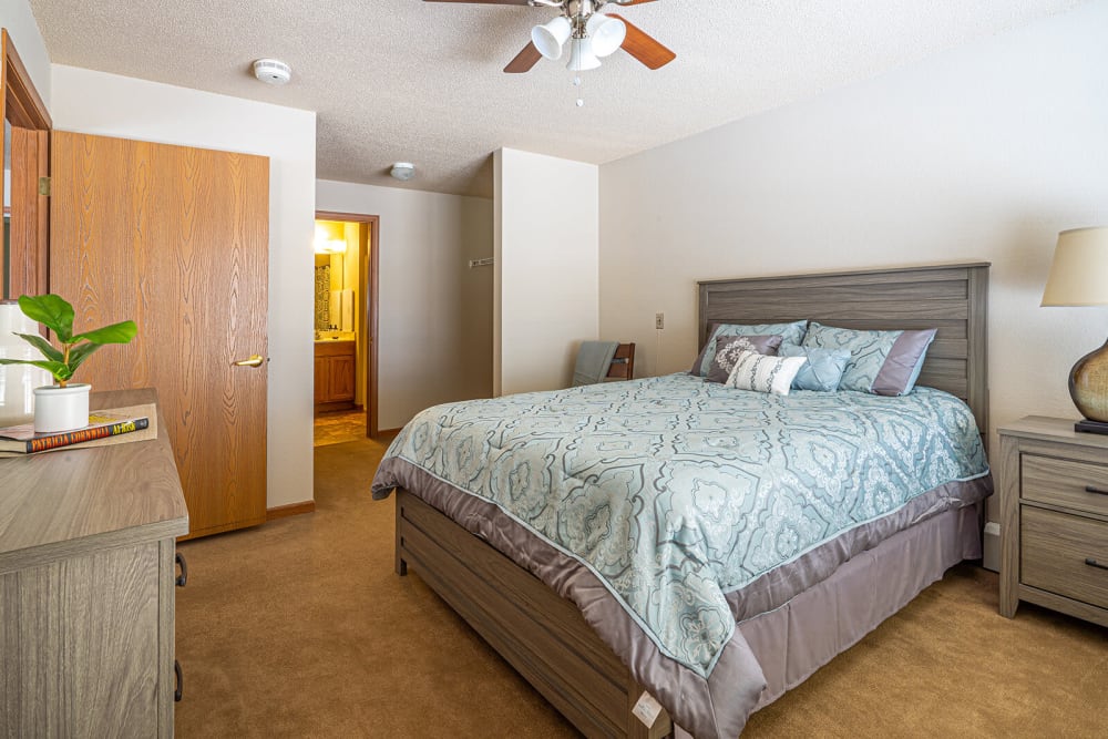 Brightly lit bedroom in an apartment at Traditions of Owatonna in Owatonna, Minnesota