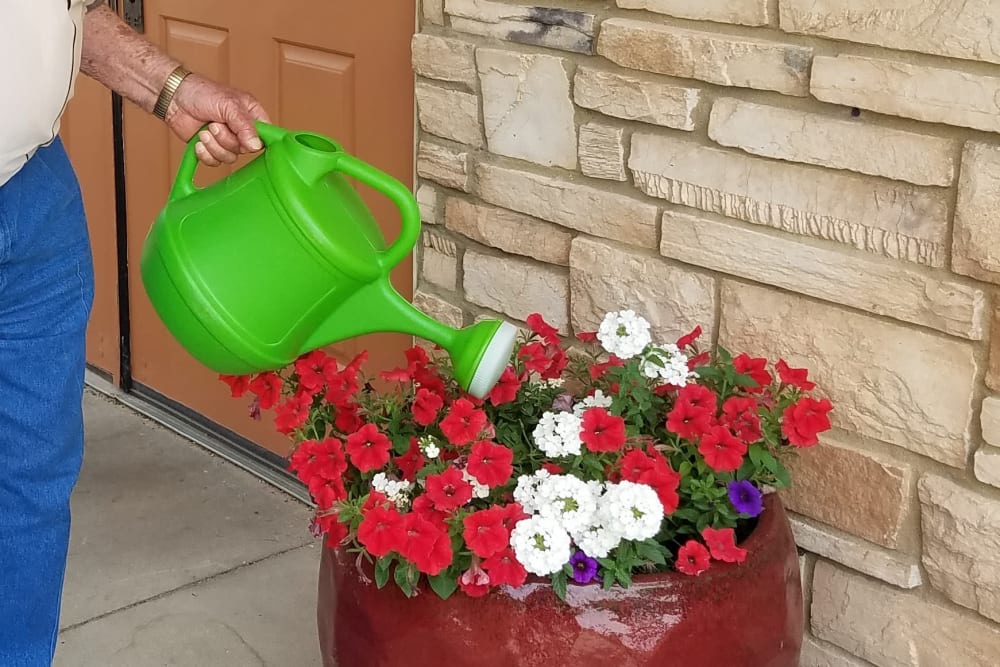 Resident watering plants and gardening at Prairie Hills Cedar Rapids in Cedar Rapids, Iowa.