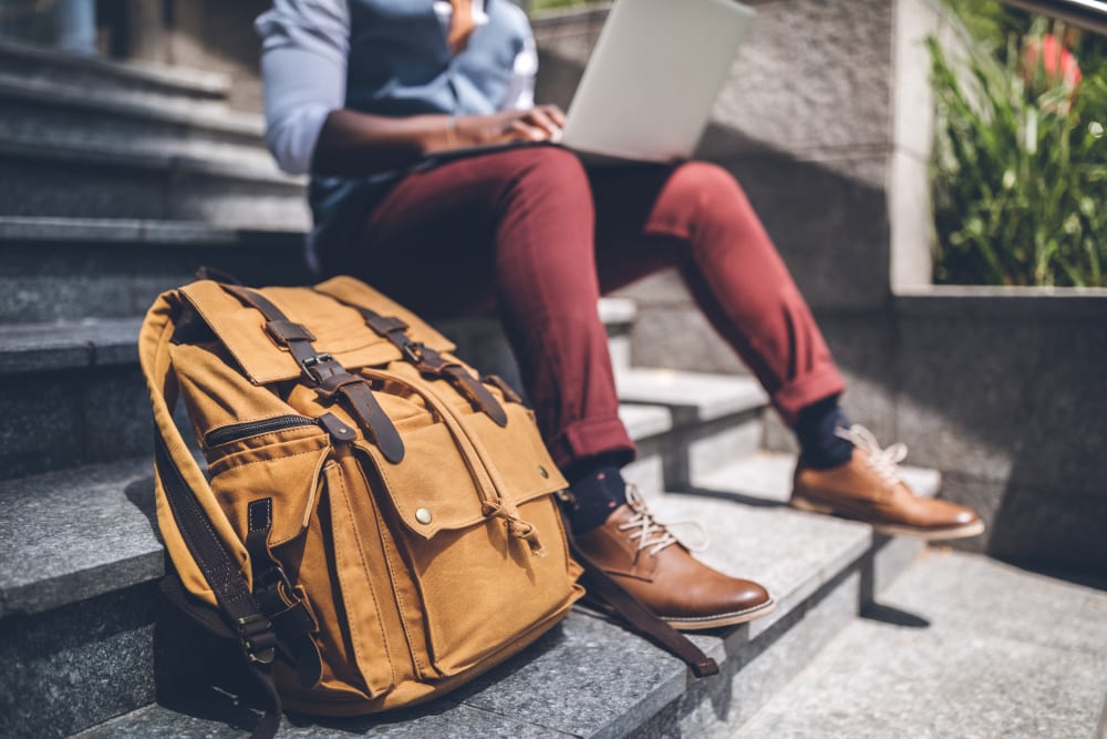 Resident sitting on some stairs with their backpack near RISE at State College in State College, Pennsylvania
