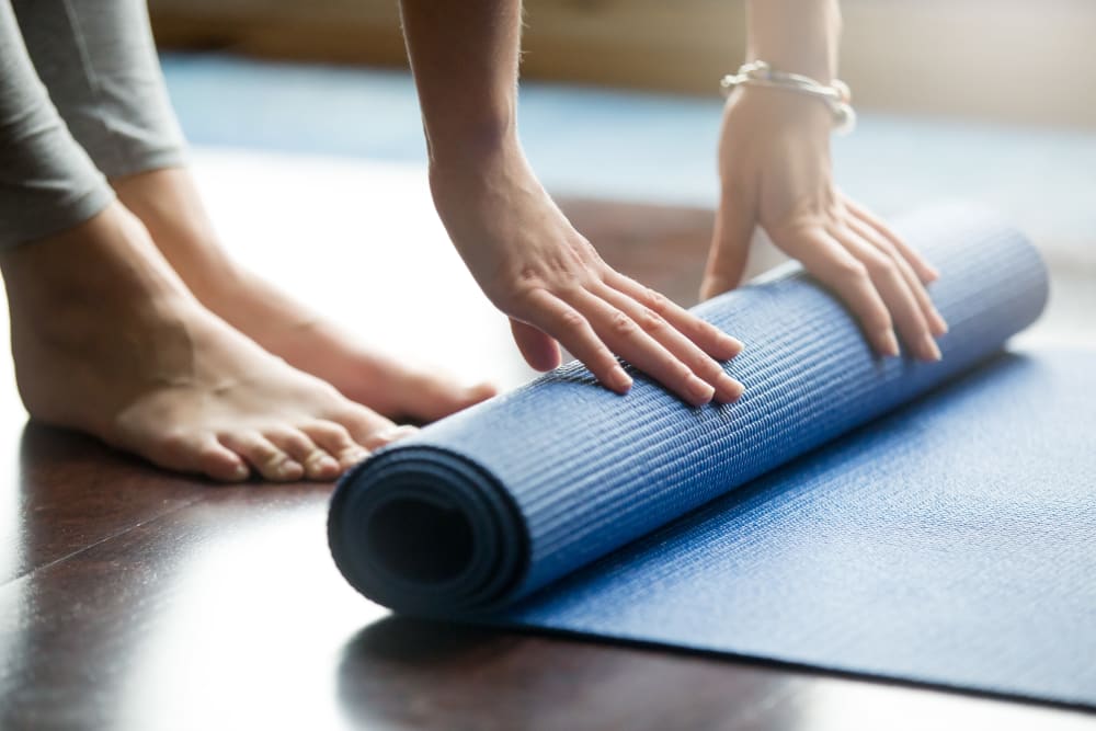Resident rolling up their yoga mat at RISE at State College in State College, Pennsylvania