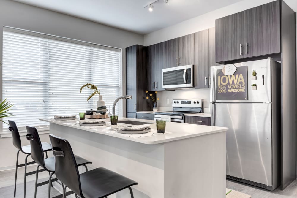 Kitchen with stainless steel appliances at LATITUDE at River Landing in Coralville, Iowa
