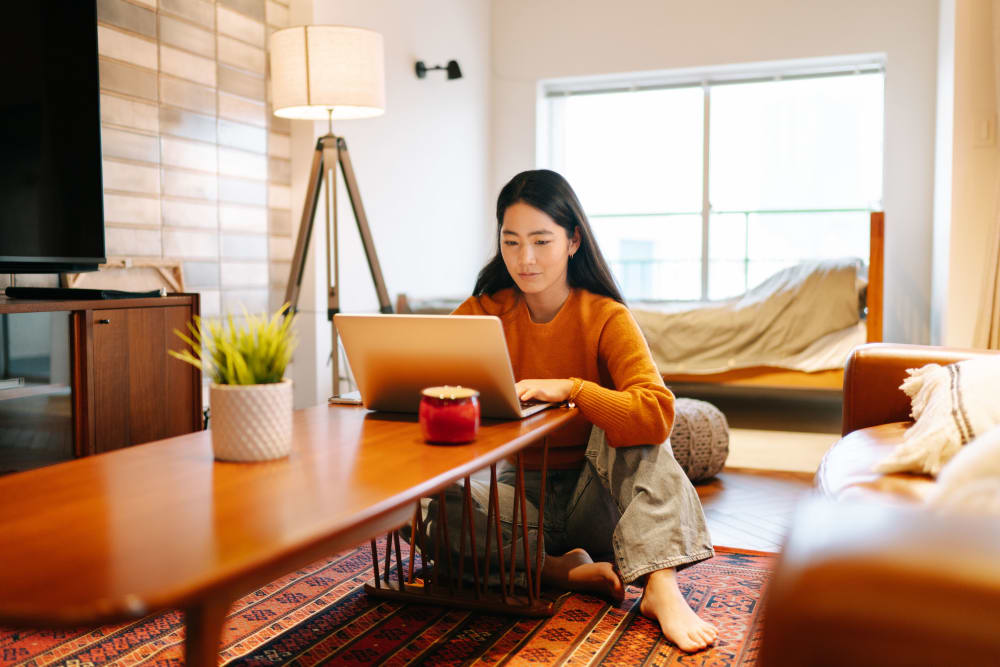 Resident working on her laptop at RISE on Apache in Tempe, Arizona
