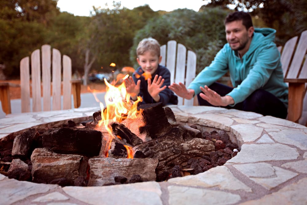 Resident family enjoying an outdoor firepit at Remington Cove Apartments in Apple Valley, Minnesota