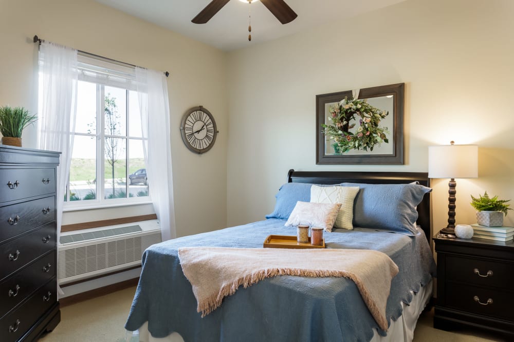 Bedroom with an air conditioning unit and a large window at Edencrest at The Legacy in Norwalk, Iowa