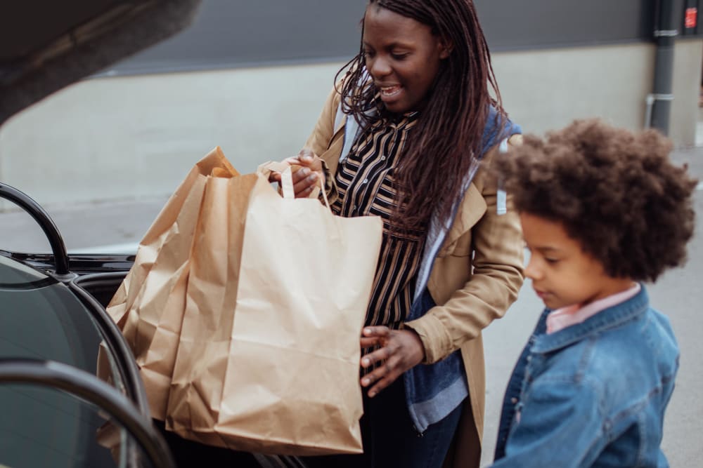 Mother and daughter removing groceries from their vehicle as they return home from shopping to Ascend in Portland, Oregon