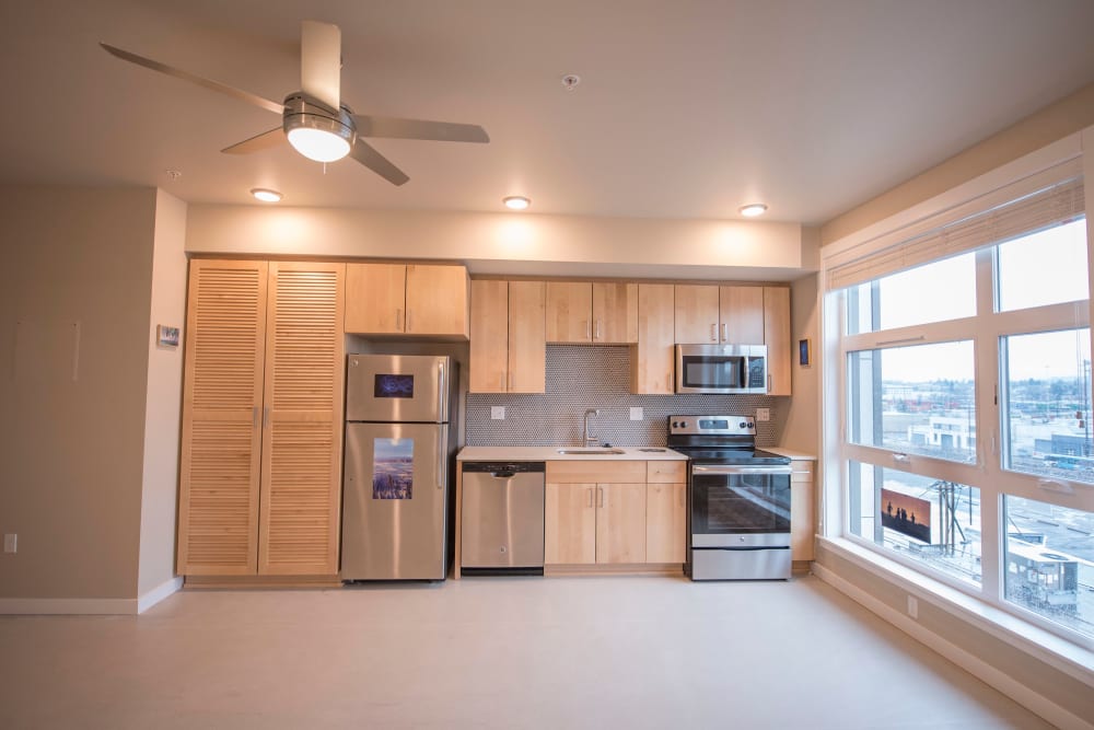 Stainless-steel appliances in a model home's kitchen with gorgeous city views from the large bay windows at Brooklyn Yard in Portland, Oregon