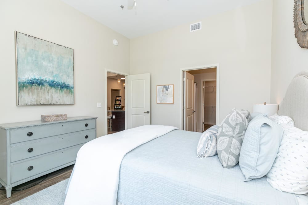 Model home's primary bedroom with an en suite bathroom and adjacent walk-in closet at The Station at River Crossing in Macon, Georgia