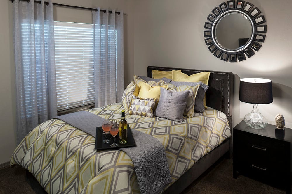 Bedroom with draped windows in a model apartment at Hyde Park at Montfort in Dallas, Texas