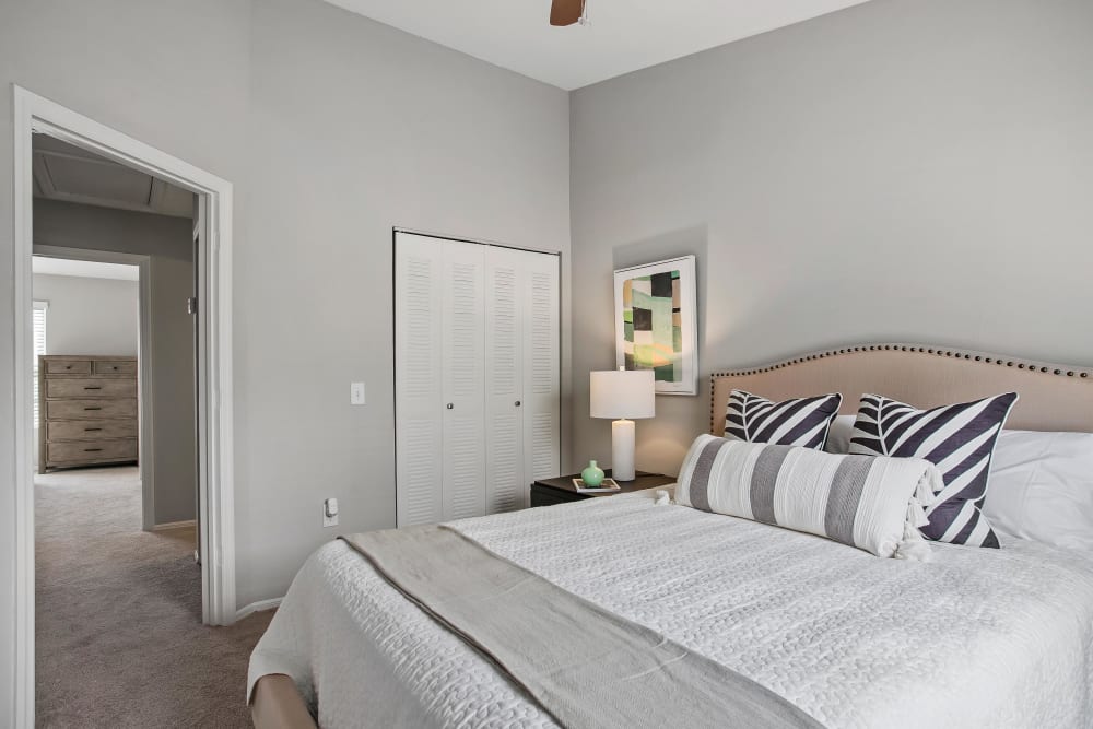 Model home's primary bedroom with plush carpeting at The Coast of Naples Florida in Naples, Florida