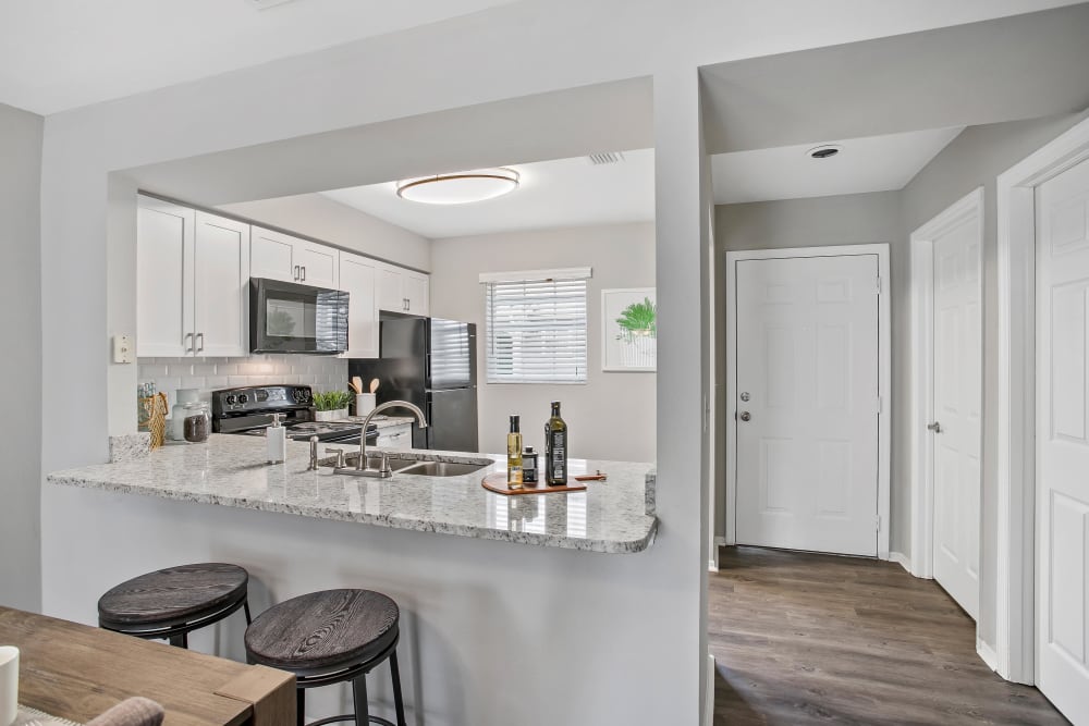 Hardwood flooring and granite countertops in a model townhome's kitchen at The Coast of Naples Florida in Naples, Florida