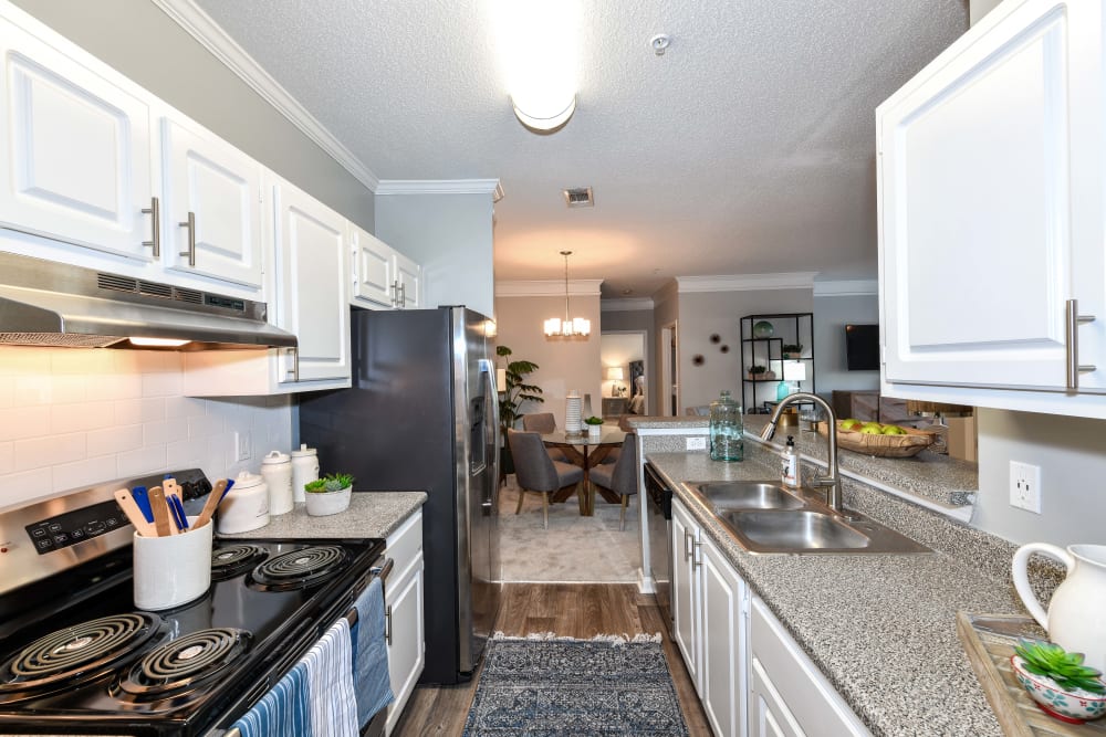 Bright white cabinetry and sleek black appliances in a model home's kitchen at 860 South in Stockbridge, Georgia