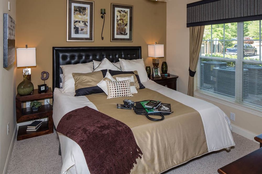 Bedroom with a large bay window and an accent wall in a model home at The Preserve at Greison Trail in Newnan, Georgia