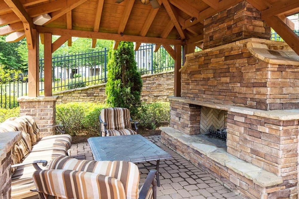 Covered outdoor lounge area with a fireplace at The Preserve at Greison Trail in Newnan, Georgia