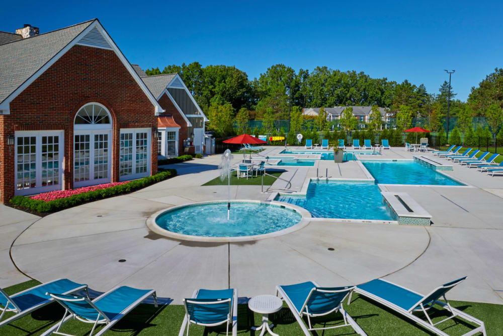 Outdoor hot tub and swimming pool with an expansive pool deck and sunny lounge chairs at Citation Club in Farmington Hills, Michigan