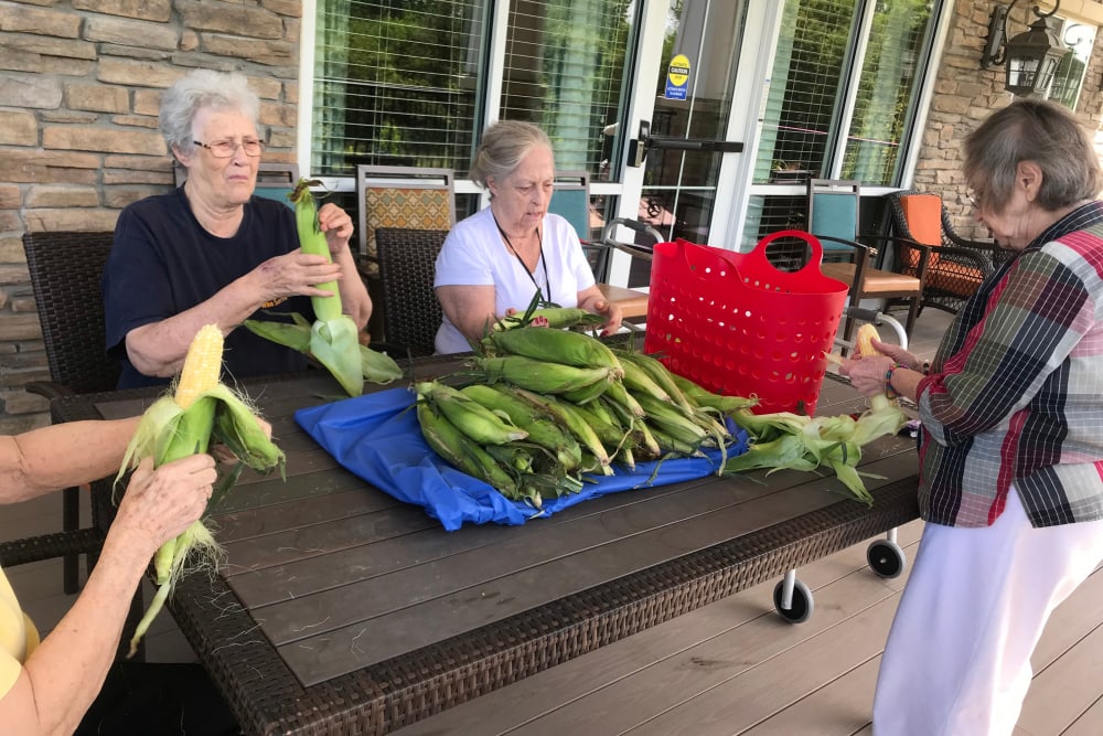 Residents shucking corn at Edencrest at Riverwoods in Des Moines, Iowa