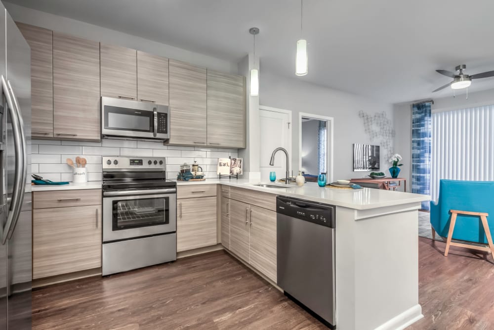 Light cabinetry and stainless-steel appliances in a model home's kitchen at The Palmer in Charlotte, North Carolina