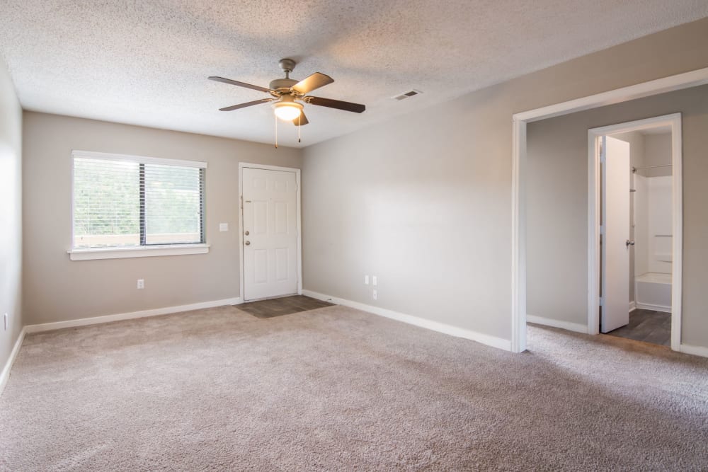 Living room with plush carpeting and a ceiling fan at 1022 West Apartment Homes in Gaffney, South Carolina