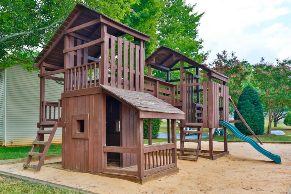 Rustic playground with a slide for resident children at Huntersville Apartment Homes in Huntersville, North Carolina
