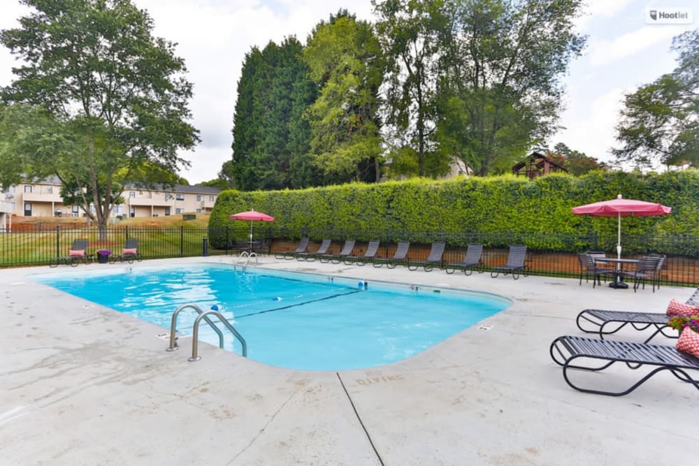 Charming swimming pool with lounge chairs at Huntersville Apartment Homes in Huntersville, North Carolina