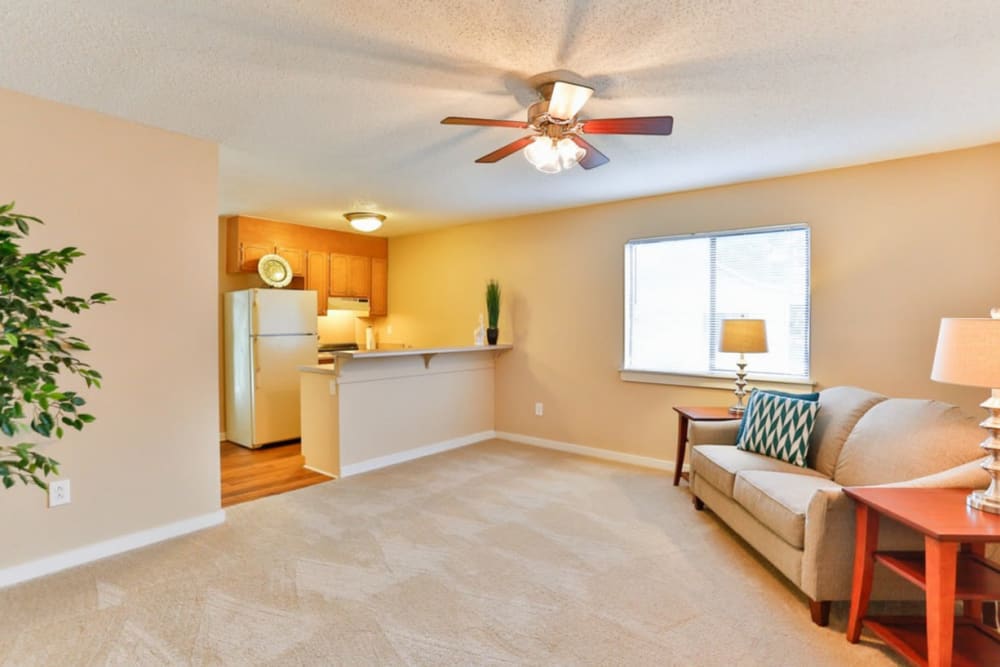 Spacious living room with a ceiling fan at Huntersville Apartment Homes in Huntersville, North Carolina