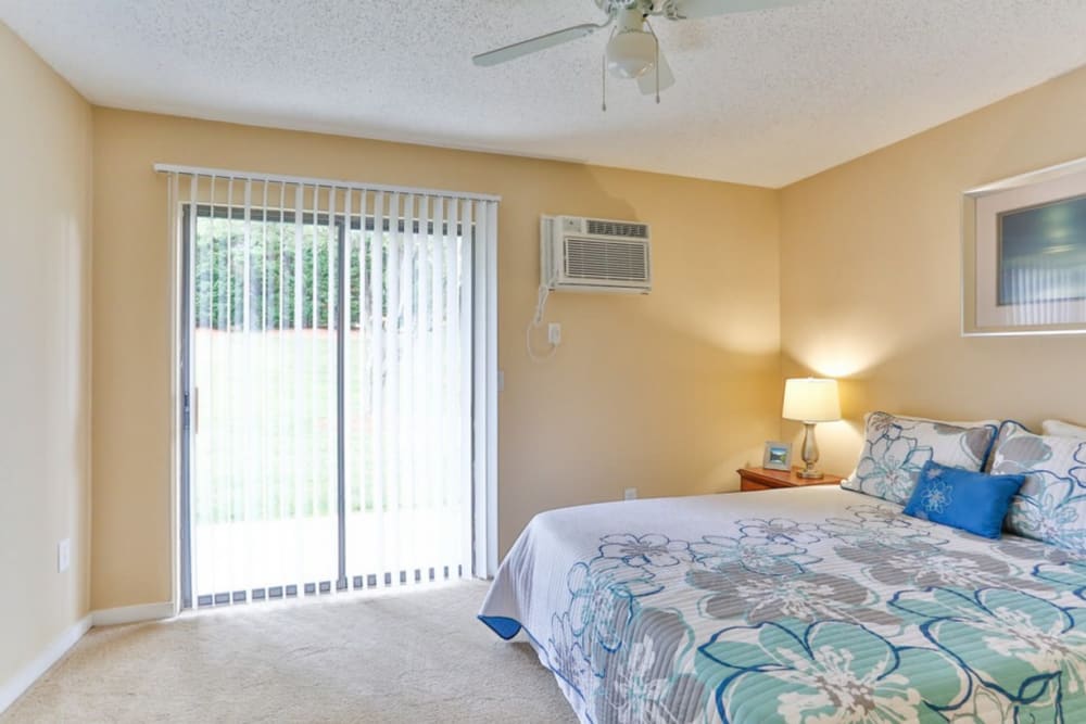 Main bedroom with balcony access at Huntersville Apartment Homes in Huntersville, North Carolina