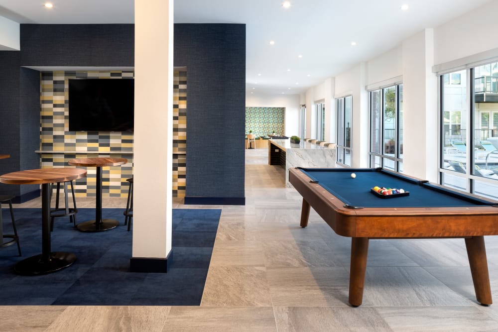 Room with a pool table and shuffle board at Olympus on Broadway in Carrollton, TX