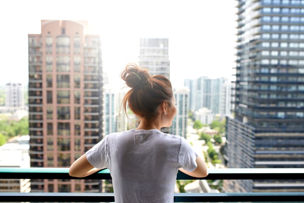 Resident enjoying a view of the city from her balcony at 17th Street Lofts in Atlanta, Georgia