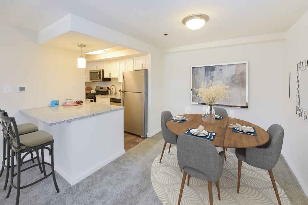 Spacious dining area and kitchen with a breakfast bar at Strafford Station Apartments in Wayne, Pennsylvania