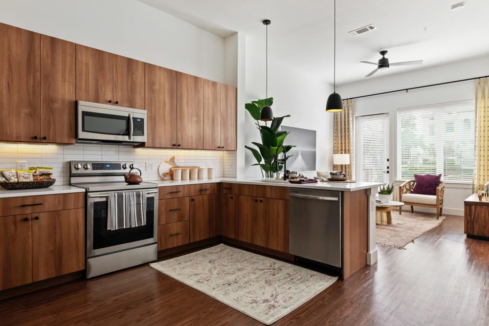 Stainless-steel appliances and custom wood cabinetry in a model home's kitchen at 4600 Ross in Dallas, Texas