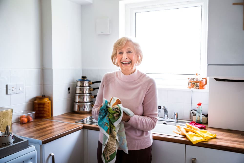 Resident washes dishes in her modern apartment at Landings of Minnetonka in Minnetonka, Minnesota