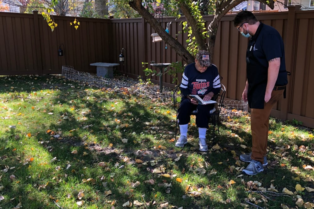 Resident and staff connect over books at Landings of Sauk Rapids in Sauk Rapids, Minnesota