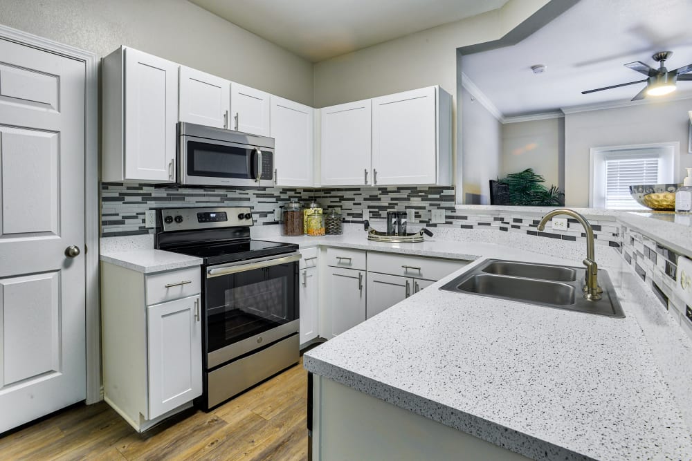 Kitchen with white cabinets and stainless-steel appliances at Bella Springs Apartments in Colorado Springs, Colorado