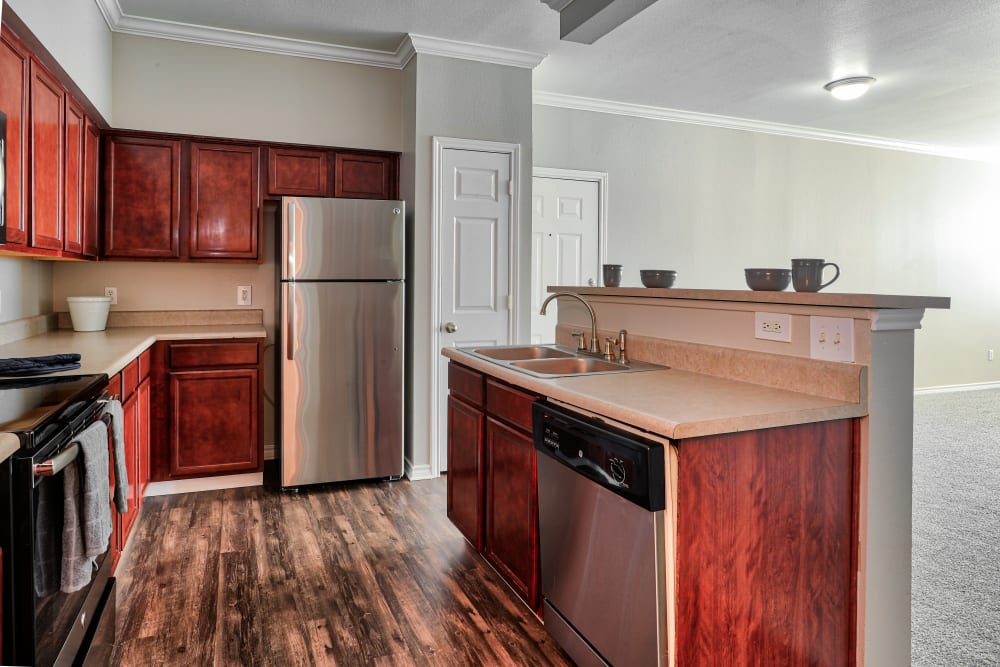 Kitchen with cherry cabinets and stainless-steel appliances at Bella Springs Apartments in Colorado Springs, Colorado